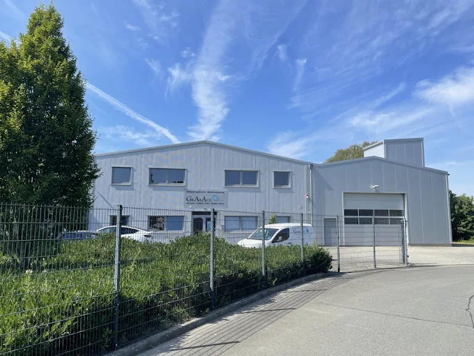 Firmengebäude von Grabacz: Werkhalle mit Rolltor, davor ein Firmenwagen