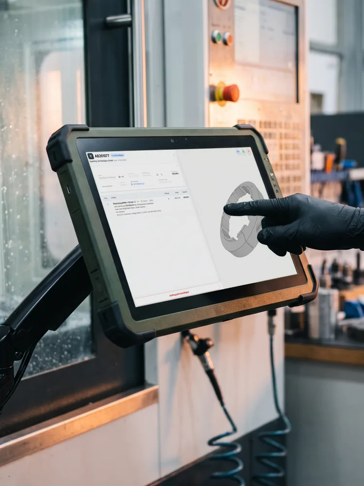 KI-generiertes Foto: Touch-Terminal an einer Fräsmaschine. Auf dem Bildschirm ist ein Auftrag mit 3D-Modell aus DIGIFULL zu sehen, ein echter Screenshot.